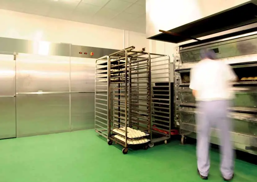 Sol vert lisse dans une boulangerie industrielle, chariot à plaques et fours
