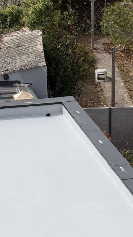 Angle du toit-terrasse avec couvertine et étanchéité remontée sous l’acrotère