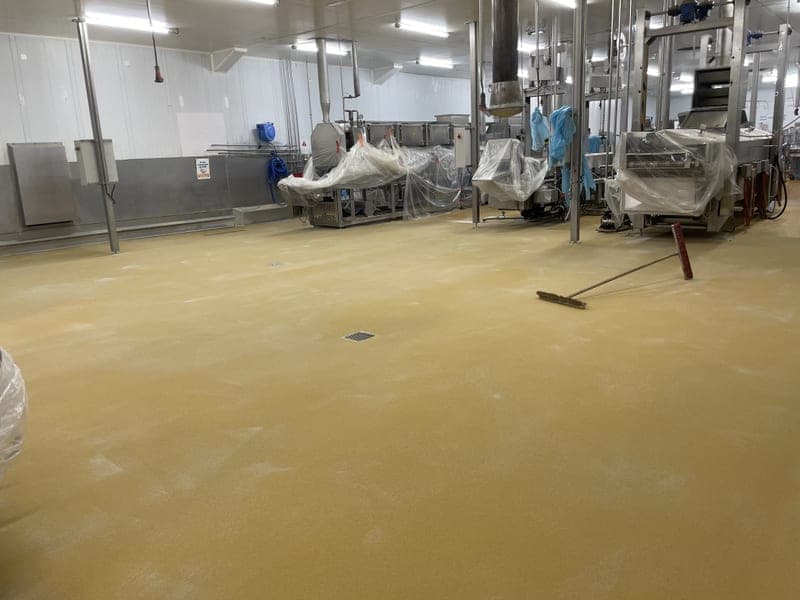 Sol en résine jaune posé en zone de production agroalimentaire, finition conforme HACCP antidérapante